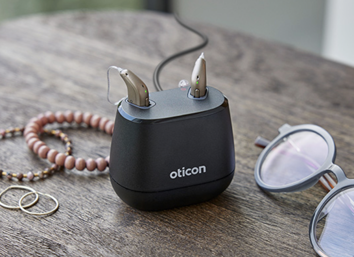 Oticon receiver-in-canal hearing aids in their charging case